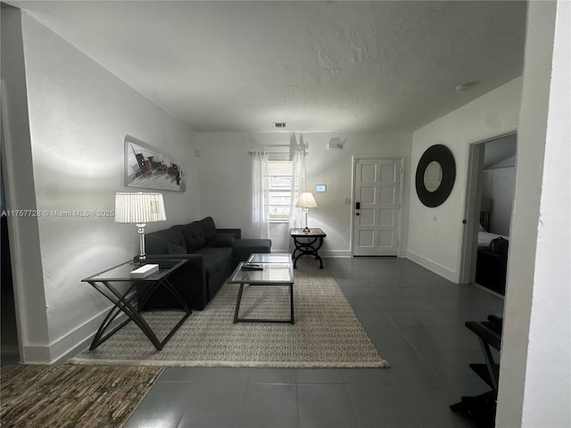 living area with a textured ceiling and baseboards