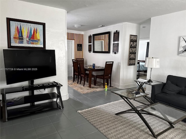 living area featuring dark tile patterned floors and baseboards