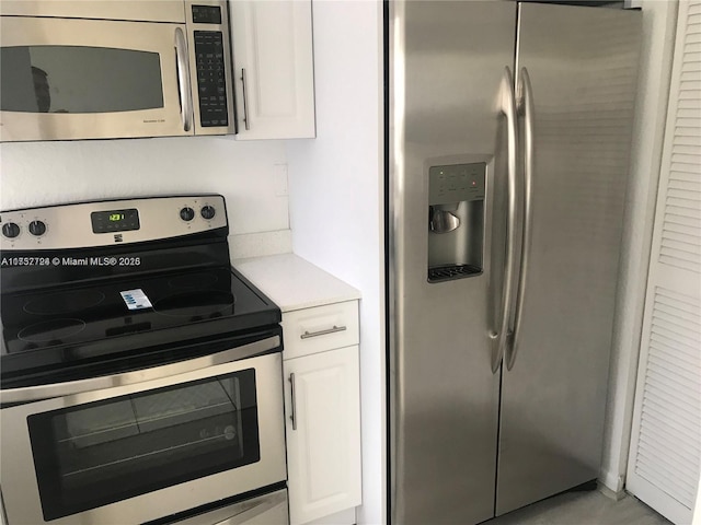 kitchen featuring white cabinets, stainless steel appliances, and light countertops