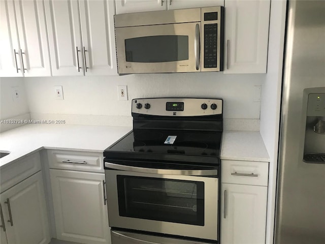 kitchen with light countertops, appliances with stainless steel finishes, and white cabinets