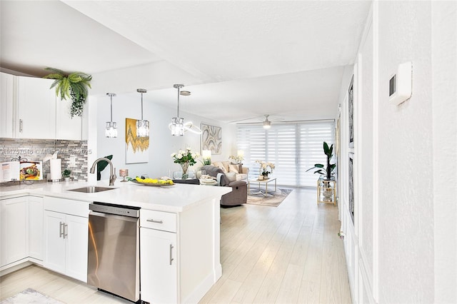 kitchen with decorative backsplash, dishwasher, open floor plan, a peninsula, and a sink