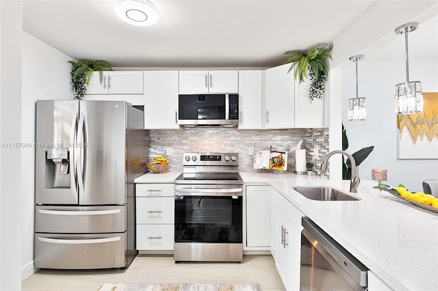 kitchen with white cabinets, appliances with stainless steel finishes, backsplash, and a sink