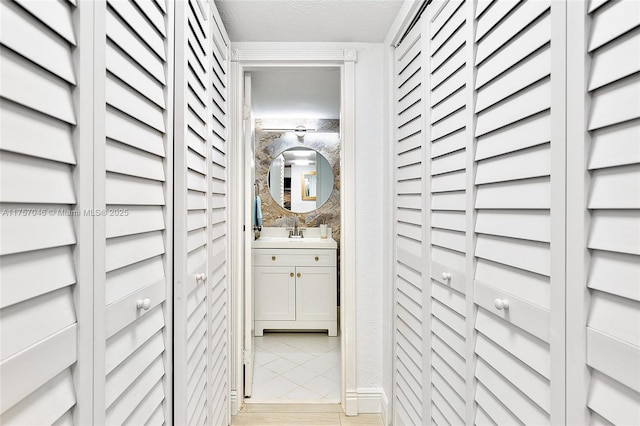 interior space with light wood-style flooring, a textured ceiling, and a sink