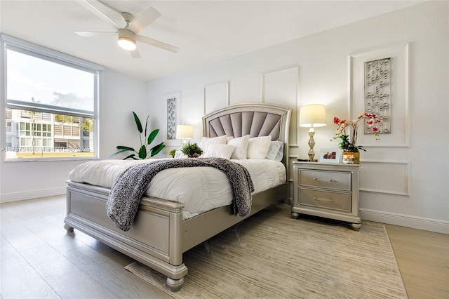 bedroom featuring light wood-style floors, ceiling fan, and baseboards