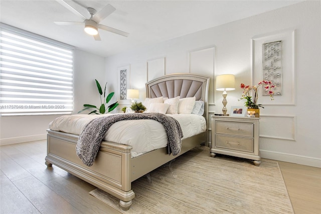 bedroom with light wood-style floors, baseboards, and a ceiling fan