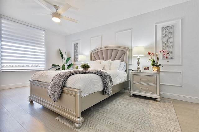 bedroom featuring light wood finished floors, baseboards, and a ceiling fan