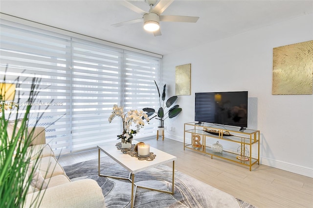 living area featuring ceiling fan, wood finished floors, and baseboards