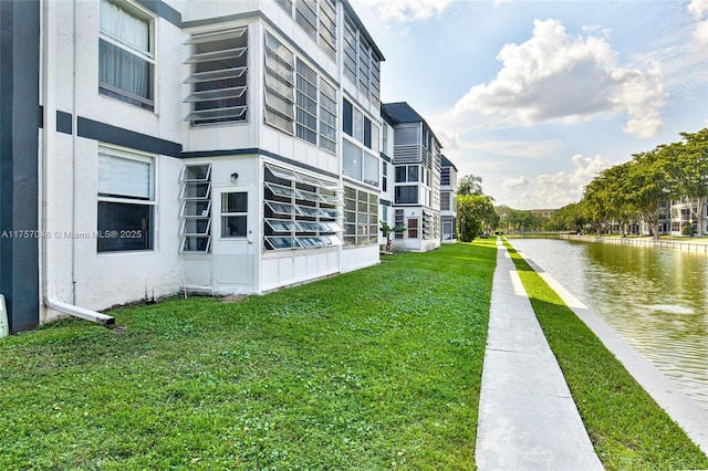 view of community featuring a yard and a water view