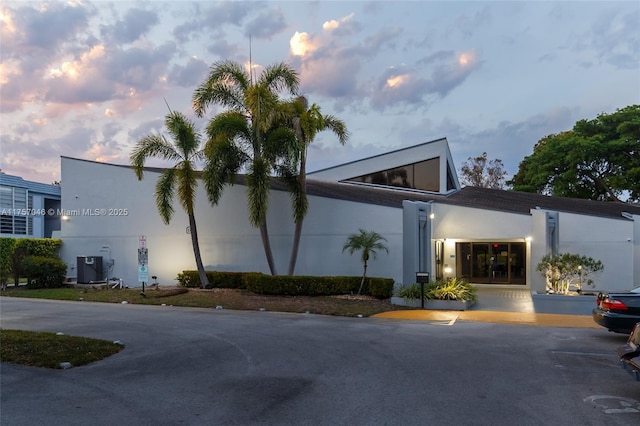 property at dusk featuring cooling unit