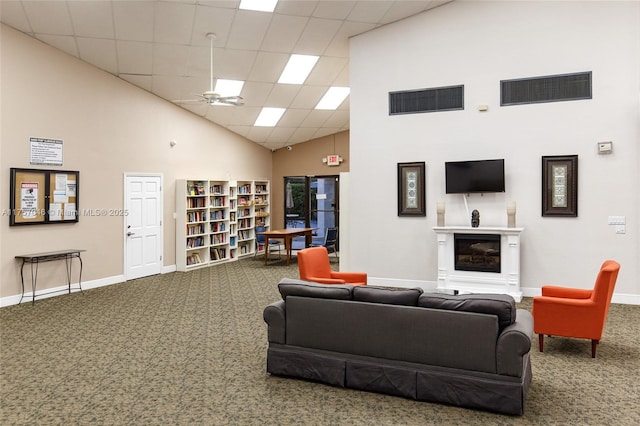 carpeted living room with high vaulted ceiling, baseboards, and visible vents