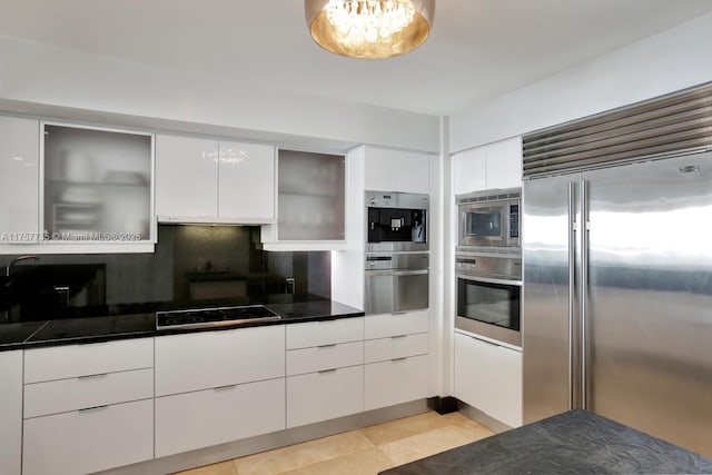 kitchen with built in appliances, modern cabinets, backsplash, and white cabinets