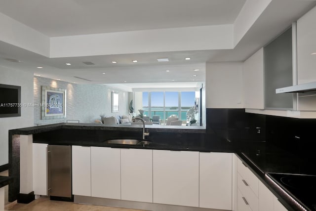 kitchen with white cabinets, a sink, decorative backsplash, and black electric cooktop