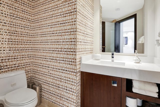 bathroom with toilet, visible vents, and vanity