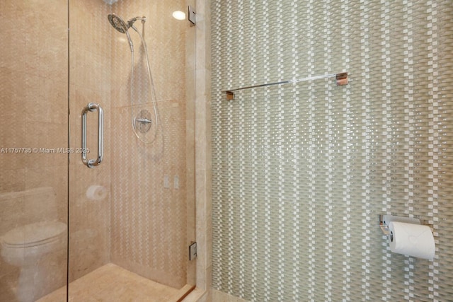 full bathroom featuring a stall shower and toilet