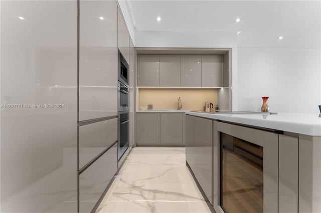 kitchen featuring marble finish floor, stainless steel appliances, modern cabinets, and gray cabinetry