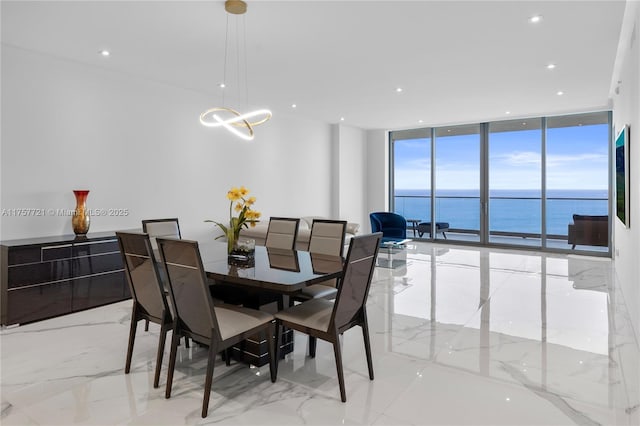 dining room featuring marble finish floor, recessed lighting, a water view, and floor to ceiling windows