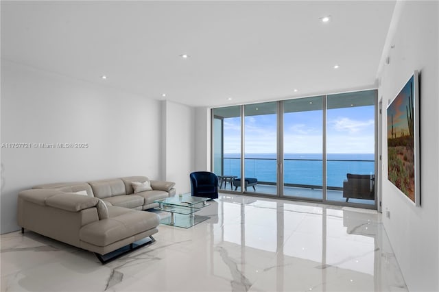 living room with expansive windows, marble finish floor, a water view, and recessed lighting