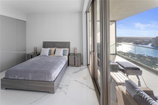 bedroom featuring marble finish floor, a water view, and floor to ceiling windows