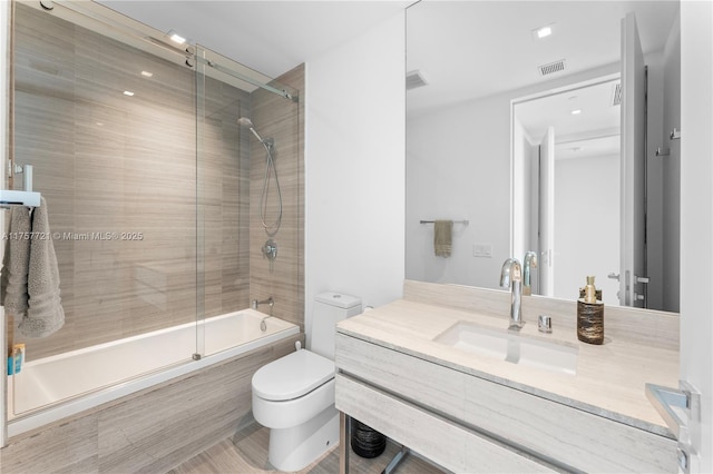 full bath featuring visible vents, tiled shower / bath combo, vanity, and toilet