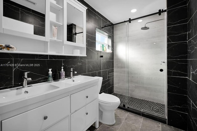 bathroom with a stall shower, a sink, toilet, and double vanity