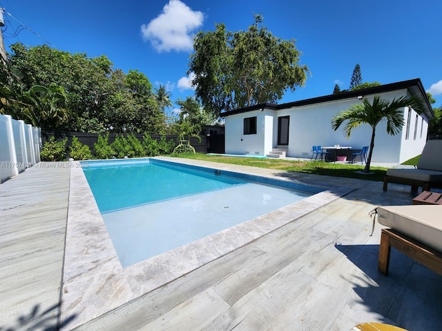 view of swimming pool with entry steps, a patio, fence private yard, and a fenced in pool