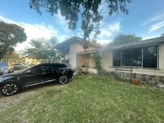 60 NW 143rd St, Miami, FL 33168 - view of property exterior with a lawn