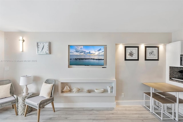 sitting room with light wood-style flooring and baseboards