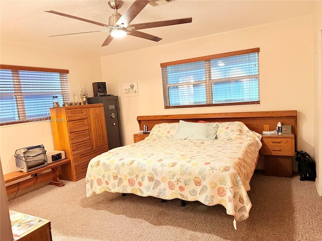 bedroom with carpet, a ceiling fan, visible vents, and a textured ceiling