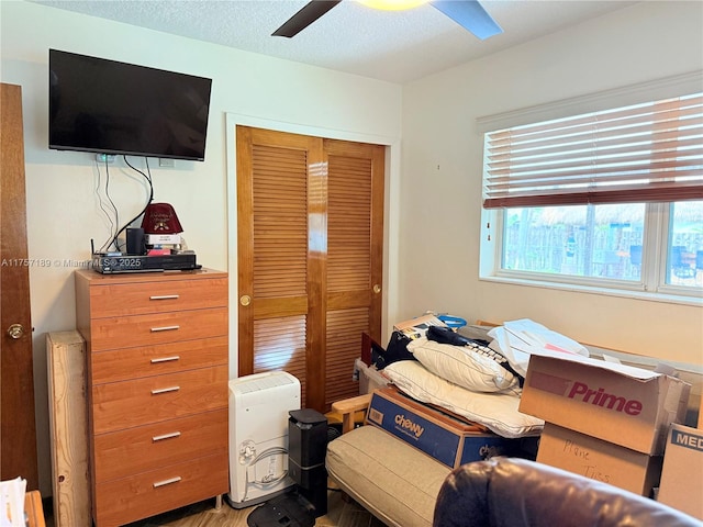 bedroom featuring a textured ceiling, ceiling fan, and a closet