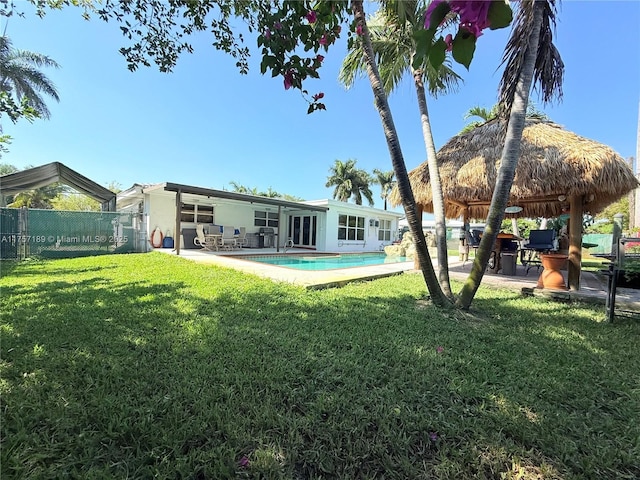 rear view of house with a patio, a yard, and fence