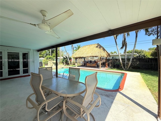 view of pool with a fenced in pool, french doors, a fenced backyard, outdoor dining space, and a patio