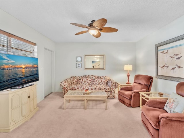 living room featuring ceiling fan, a textured ceiling, and light colored carpet