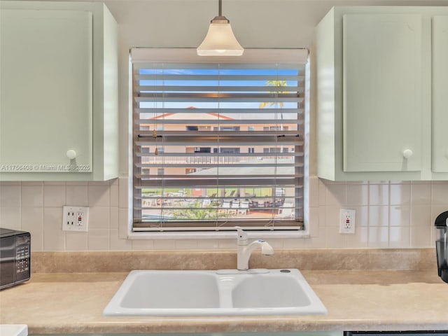 kitchen with light countertops, a healthy amount of sunlight, a sink, and green cabinetry