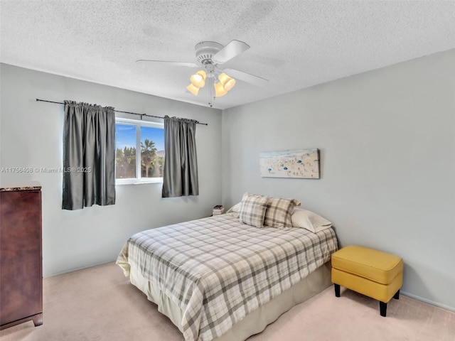 carpeted bedroom featuring a ceiling fan and a textured ceiling