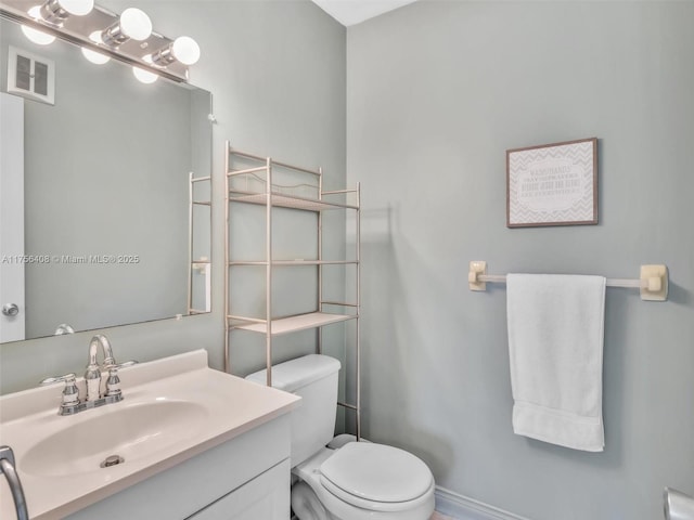 bathroom with visible vents, vanity, and toilet