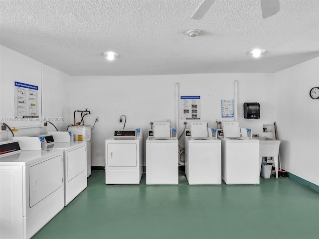 shared laundry area featuring baseboards, water heater, a textured ceiling, and washing machine and clothes dryer