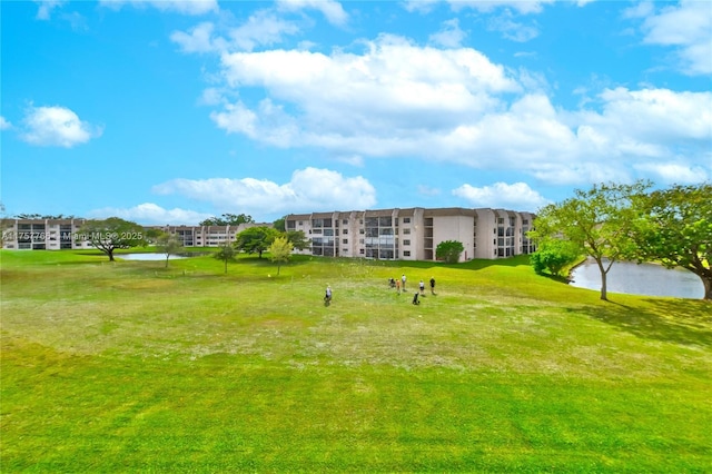 view of home's community with a water view and a yard