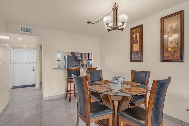 dining space featuring an inviting chandelier, baseboards, and visible vents