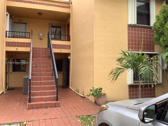 view of building exterior featuring central AC and stairs