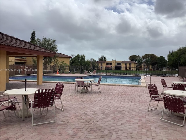 pool with a patio area and fence