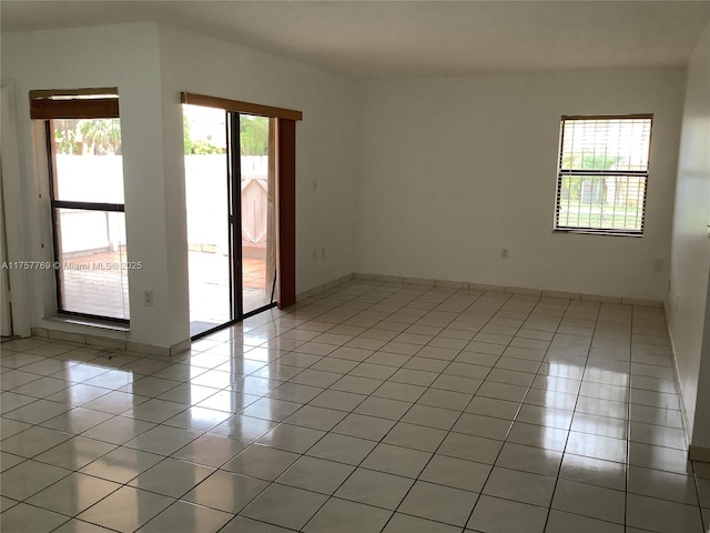 spare room with light tile patterned floors and baseboards