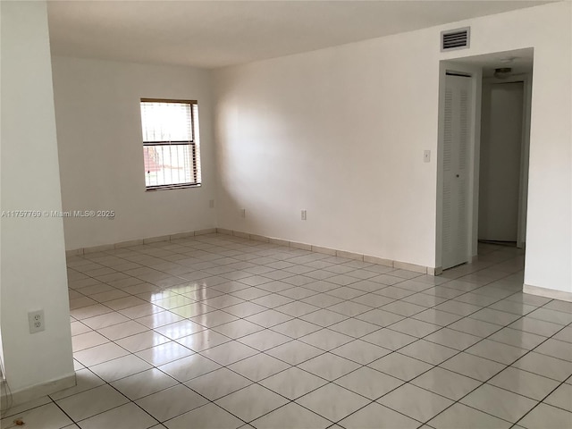 spare room featuring visible vents, baseboards, and light tile patterned floors