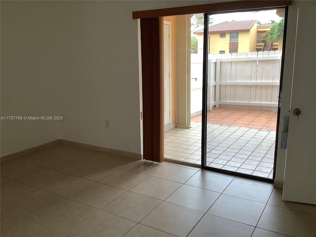 doorway featuring tile patterned flooring and baseboards