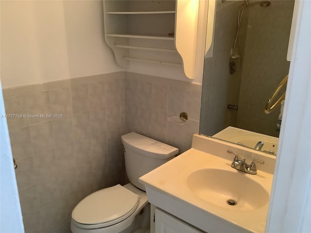 bathroom with tile walls, vanity, and toilet