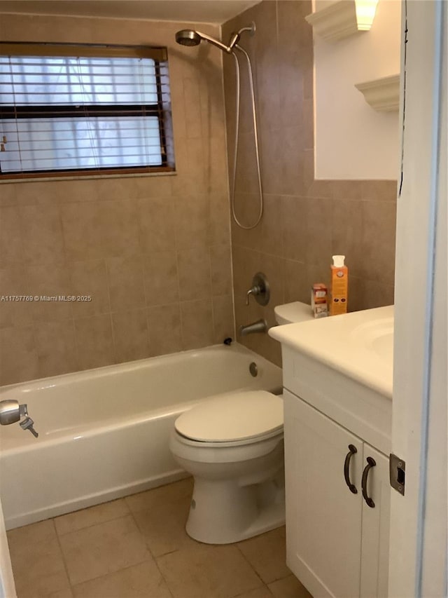 full bathroom with tile patterned flooring, toilet, vanity, tile walls, and  shower combination