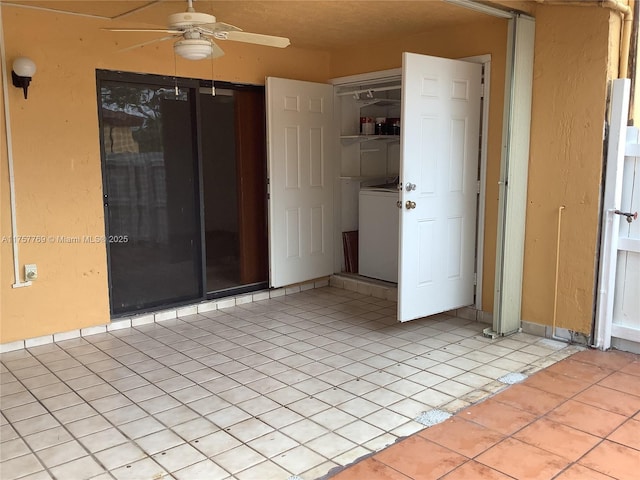 empty room with washer / clothes dryer, light tile patterned flooring, and a ceiling fan