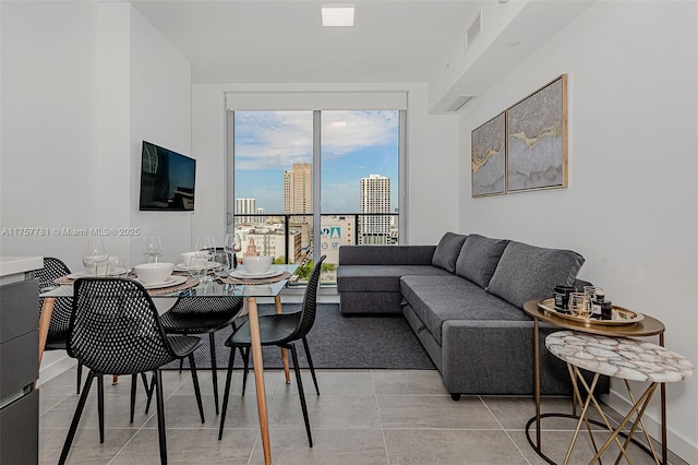 living room featuring visible vents, a wall of windows, and light tile patterned flooring