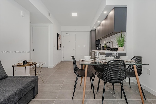 dining space featuring light tile patterned floors, visible vents, and baseboards