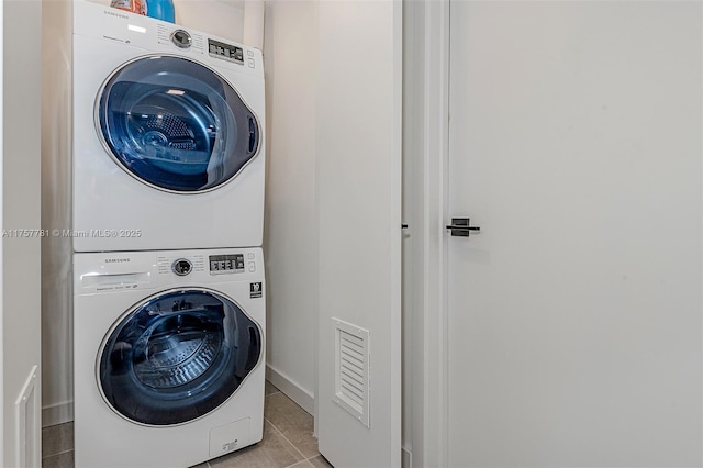 laundry area with laundry area, stacked washing maching and dryer, and tile patterned floors