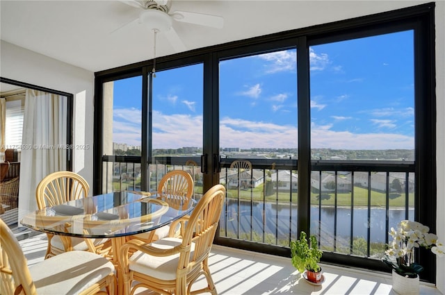 sunroom featuring ceiling fan, a water view, and a wealth of natural light